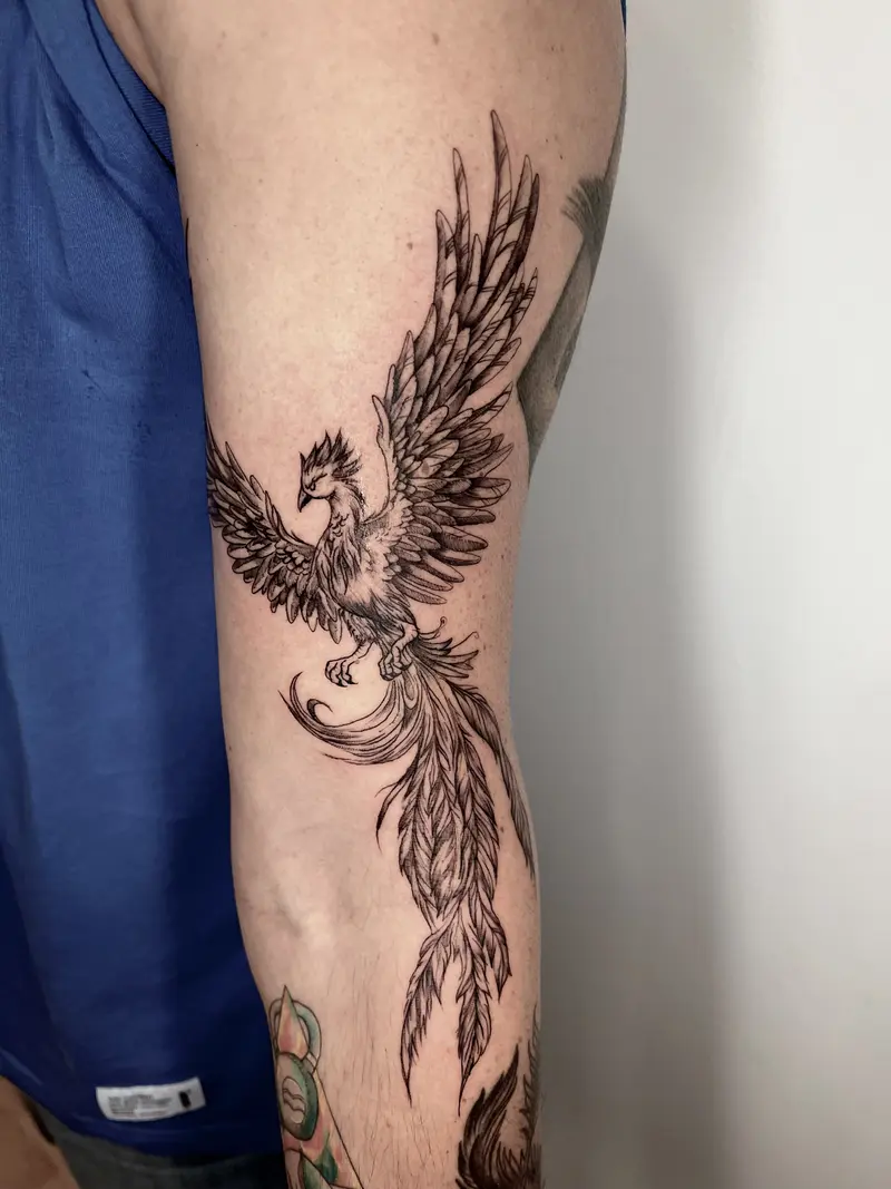 Ave fénix en vuelo con alas abiertas, estilo blackwork.