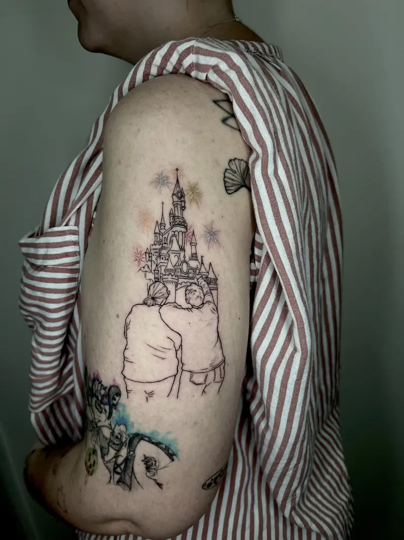 Escena emotiva en fine line: dos figuras abrazadas frente a un castillo, con pequeños destellos tipo fuegos artificiales.